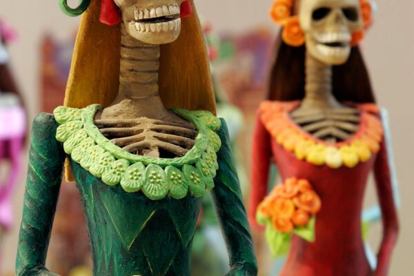 Figuras de Catrinas con vestidos de colores y sombreros de flores