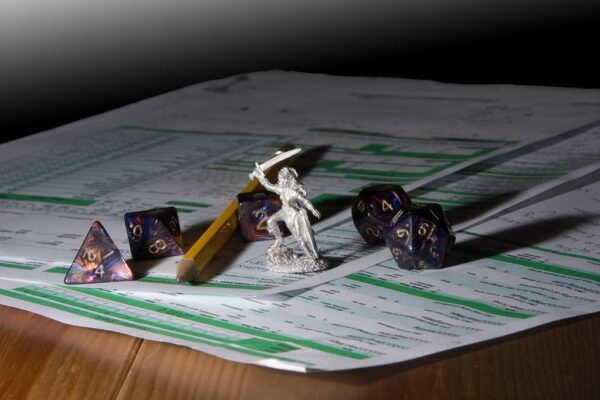 Dados poliédricos, miniatura y hoja de personaje de un juego de rol