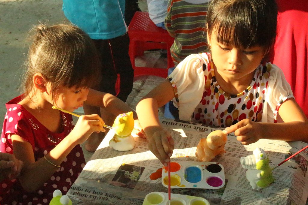 Niñas pintando figuras de yeso con acuarelas